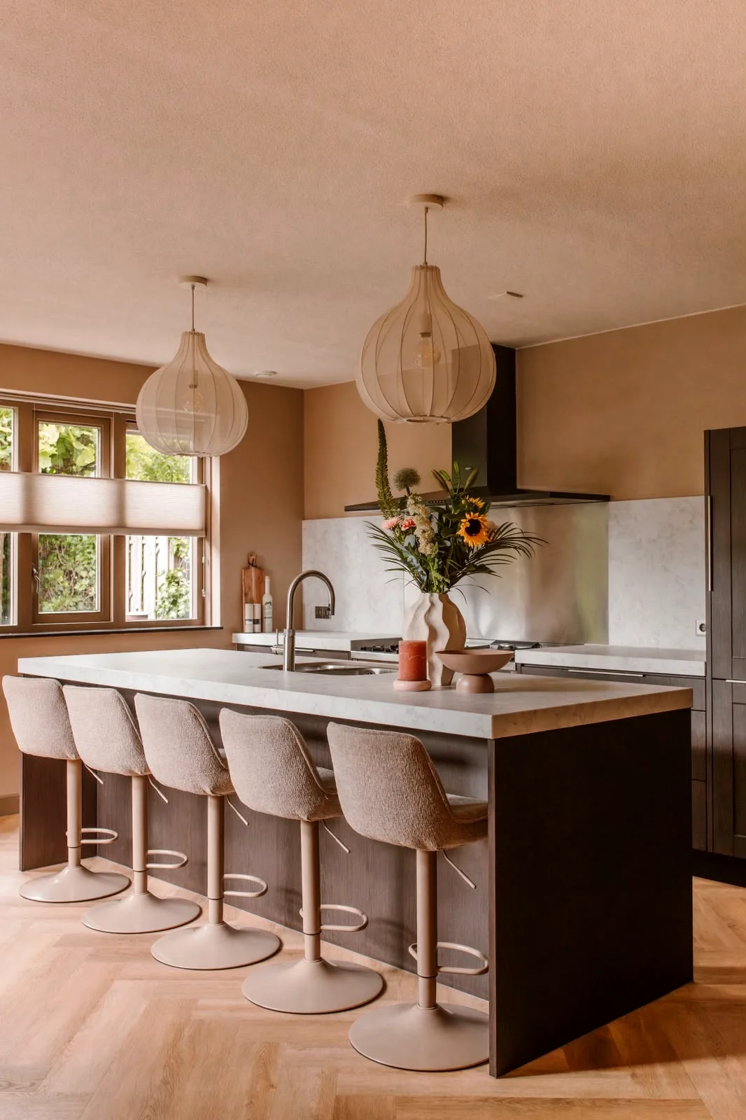 De voormalige rode keuken, nu met donkere houtlook en een licht marmerlook eiland